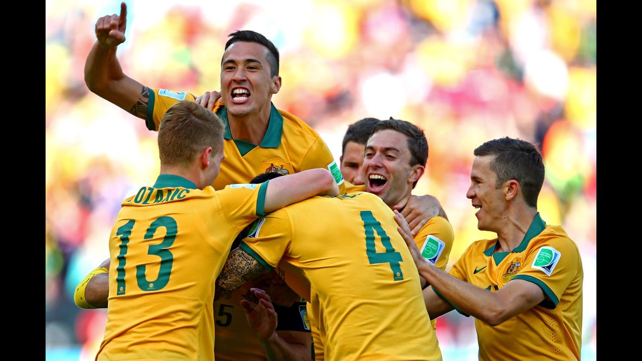 Australian players mob captain Mile Jedinak after Jedinak's penalty kick gave them a 2-1 lead in the second half.