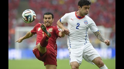 Pedro, left, kicks the ball near Chilean defender Eugenio Mena.