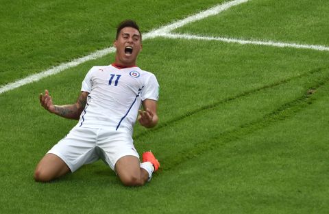 Chile forward Eduardo Vargas slides on the grass after scoring the game's opening goal.