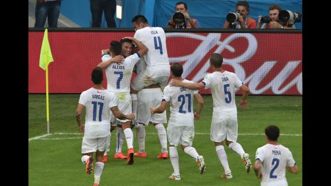 Chilean players celebrate together after midfielder Charles Aranguiz gave them a 2-0 lead against Spain. Chile won the match by that score, eliminating the defending world champions from the soccer tournament.