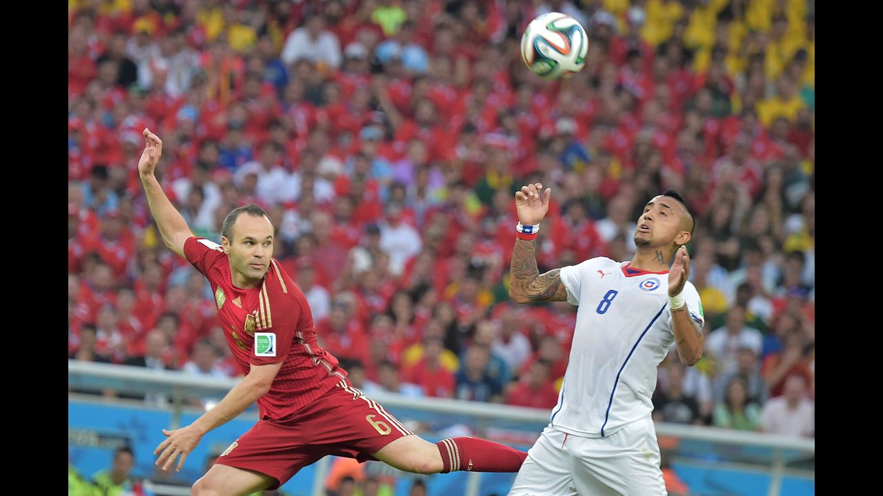 Iniesta and Chilean midfielder Arturo Vidal compete during the match.