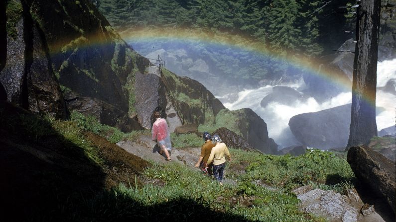 Hikers walk past a rainbow caused by mist from Vernal Falls, circa 1962. There are <a href="index.php?page=&url=http%3A%2F%2Fwww.nps.gov%2Fyose%2Fplanyourvisit%2Fhiking.htm" target="_blank" target="_blank">800 miles of trails</a> at the park. 