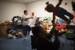 Volunteers prepare to hand out clothing and supplies for immigrant families arriving at the bus station.