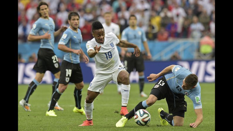 England's Raheem Sterling tries to dribble away from Uruguay defender Jose Maria Gimenez, right.