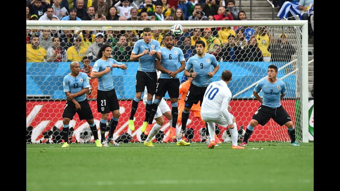 Rooney tries to curl a free kick around Uruguayan defenders.