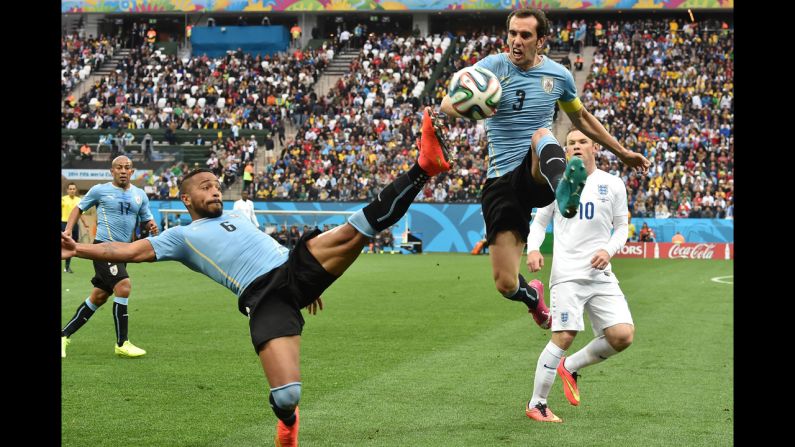 Uruguay midfielder Alvaro Pereira, left, and teammate Diego Godin reach for the ball in the first half.