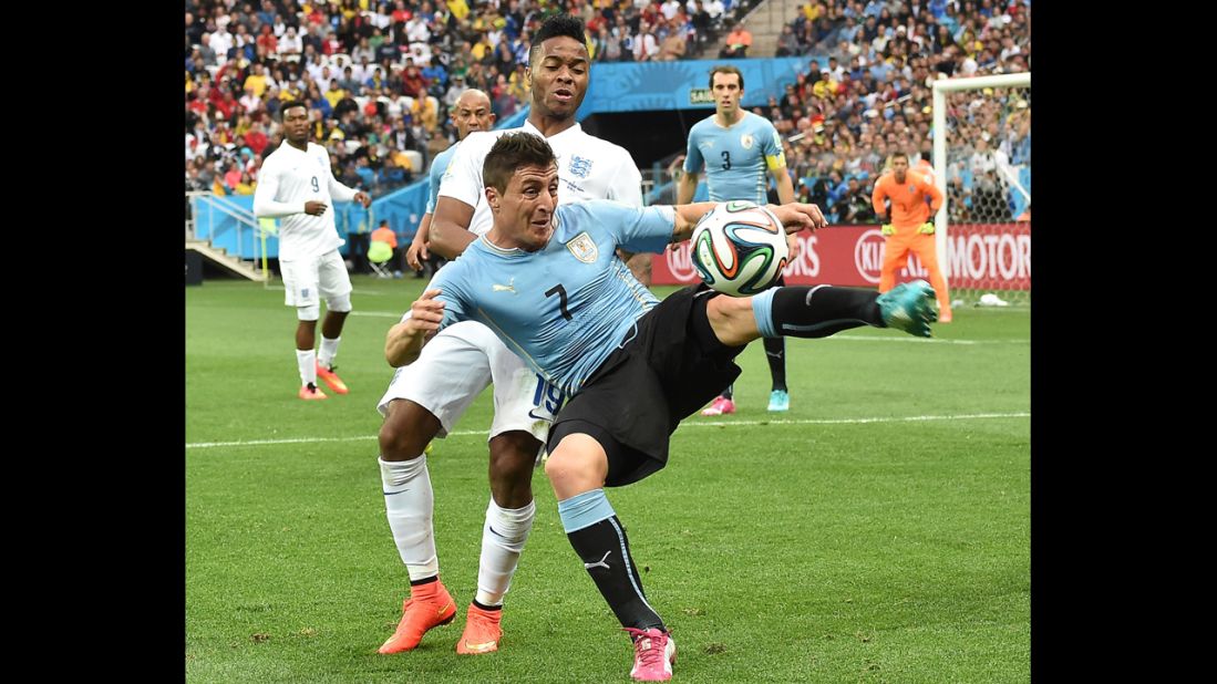 Uruguay midfielder Cristian Rodriguez shields the ball from Sterling.