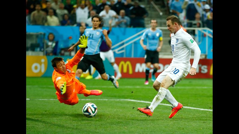 Rooney slips the ball past Uruguay goalkeeper Fernando Muslera.