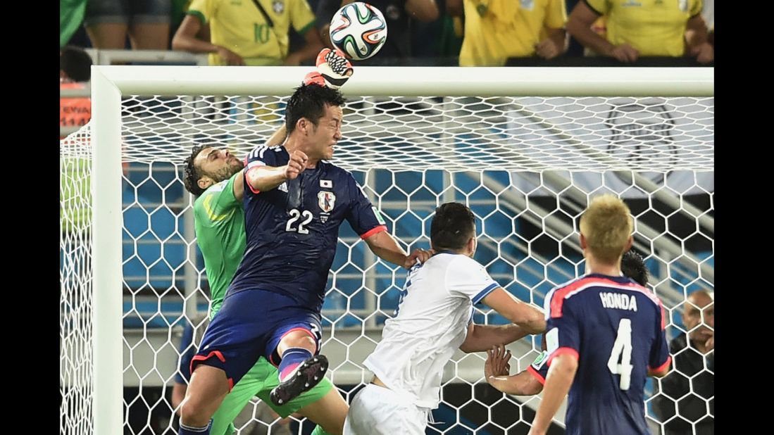 Greece's goalkeeper Orestis Karnezis, left, vies for the ball with Japan defender Maya Yoshida, second left  during a World Cup match on Thursday, June 19, in Natal, Brazil. The game ended in a draw. 