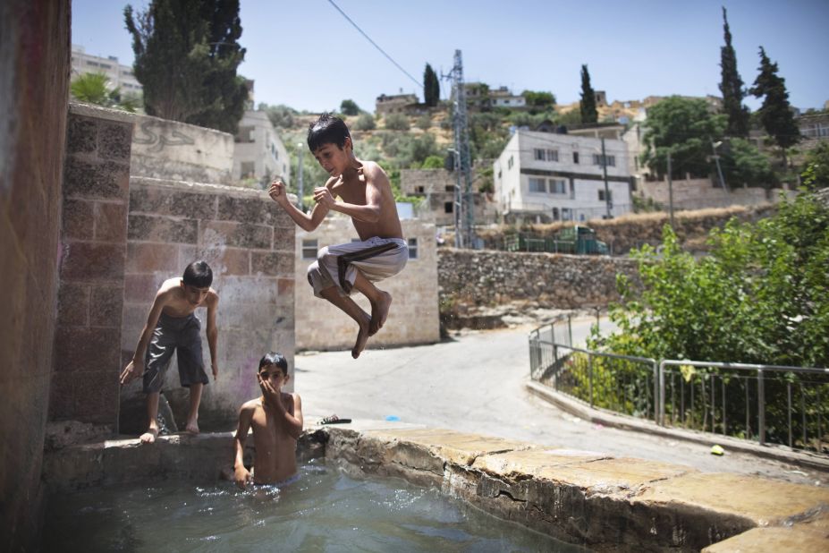 Palestinian children jump in an ancient spring in the West Bank village of Battir, which was the first site UNESCO added to its World Heritage List during its June 2014 meeting in Qatar. 