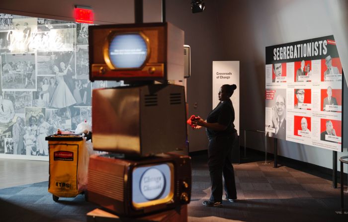 An employee cleans an exhibit on segregation.