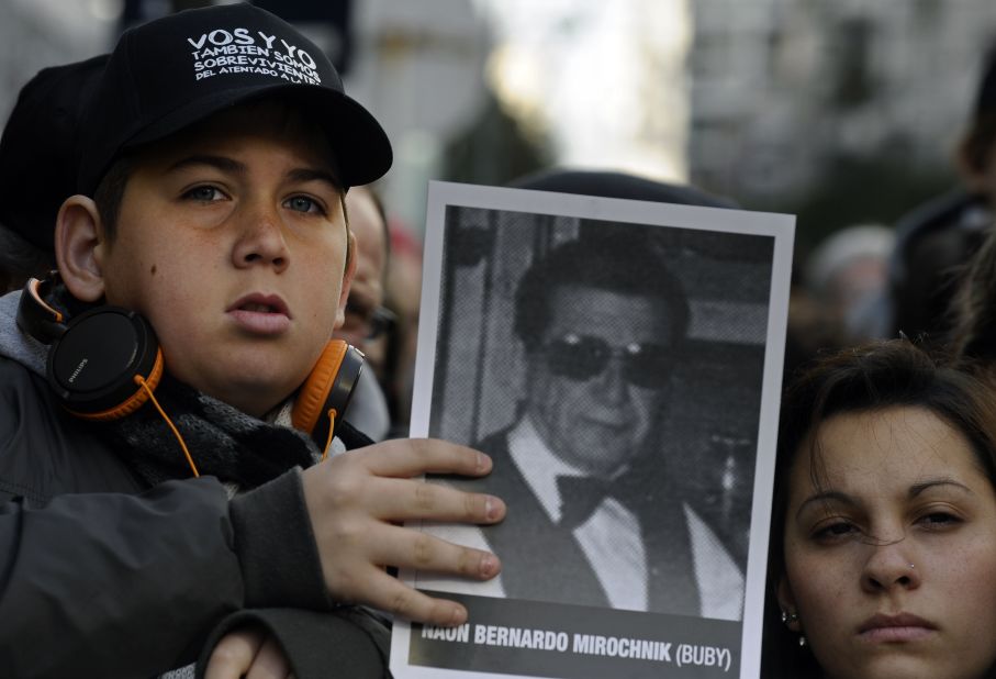 A boy holds a picture of a victim during a memorial parade in Buenos Aires in 2012.