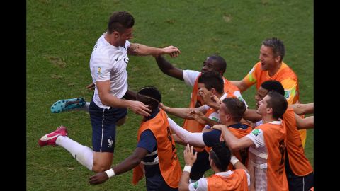 After scoring the opening goal of the match, Giroud celebrates with his French teammates on the sideline.