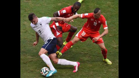 French forward Olivier Giroud, left, dribbles past two Swiss players.