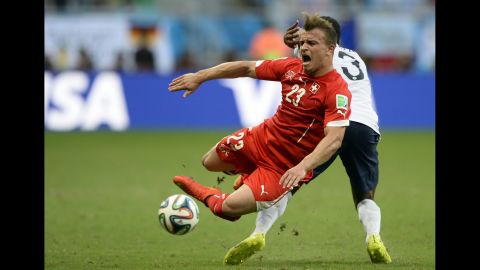 Switzerland midfielder Xherdan Shaqiri falls over during a challenge by France defender Patrice Evra.
