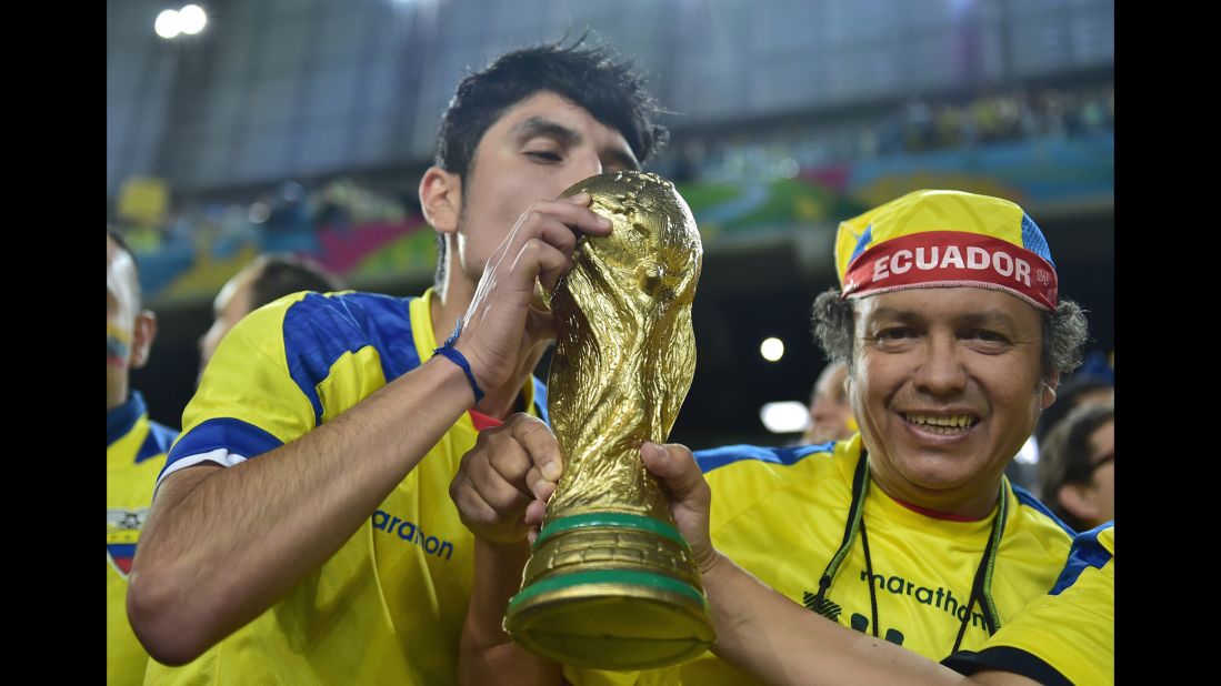 Ecuador supporters pose with a World Cup trophy replica before the game. 