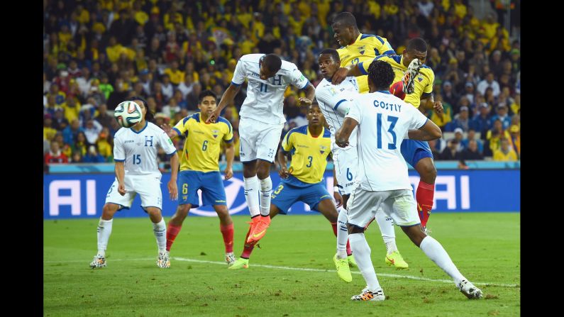 Enner Valencia of Ecuador scores his team's second goal on a header against Jerry Bengtson and Juan Carlos Garcia of Honduras on Friday, June 20, in Curitiba, Brazil. The goal brought the score to 2-1, Ecuador.
