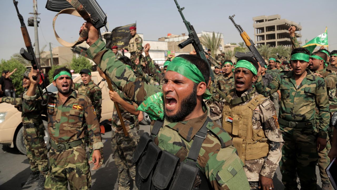 Volunteers in the newly formed "Peace Brigades" raise their weapons and chant slogans against the al-Qaida-inspired Islamic State of Iraq and the Levant during a parade in the Shiite stronghold of Sadr City, Baghdad, Iraq, Saturday, June 21, 2014. The armed group was formed after radical Shiite cleric Muqtatda al-Sadr called to form brigades to protect Shiite holy shrines against possible attacks by Sunni militants. (AP Photo/Khalid Mohammed)