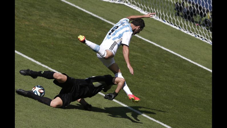 Argentina forward Gonzalo Higuain, right, and Iran's goalkeeper Alireza Haqiqi vie  for the ball. 