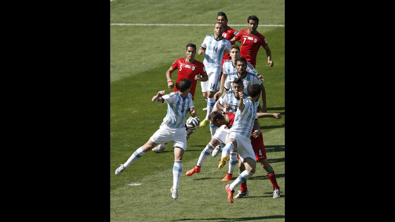 Iran defender Jalal Hosseini, second right, heads the ball.