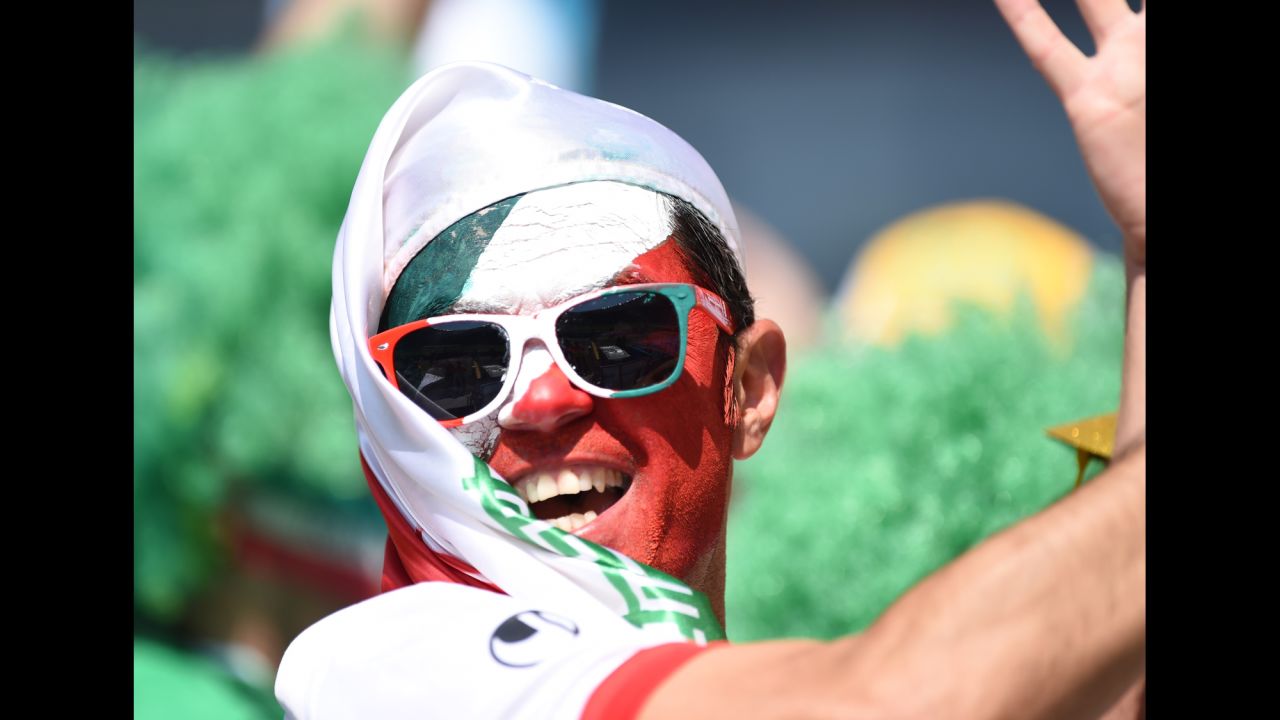 A fan painted with the Iranian colors poses before the match.