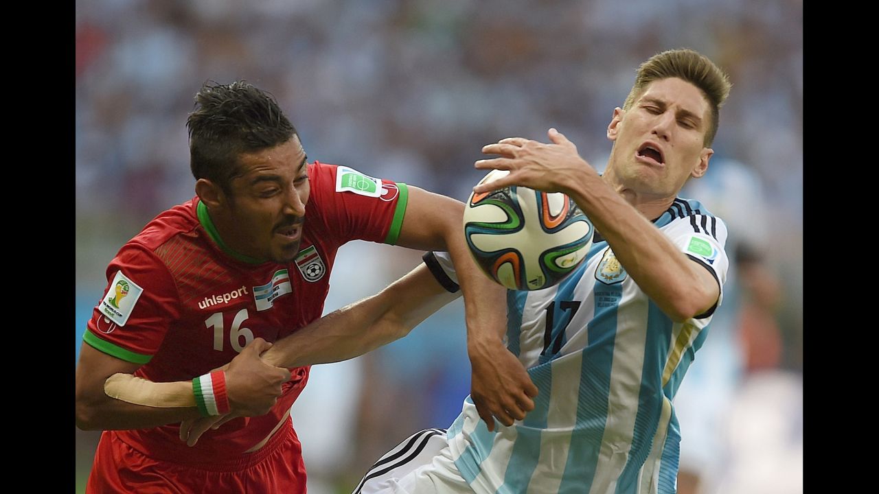 Iran forward Reza Ghoochannejhad, left and Argentina defender Federico Fernandez vie for the ball. 