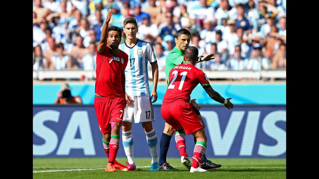 Members of the Iranian team appeal to referee Milorad Mazic, claiming Argentina's Pablo Zabaleta fouled Ashkan Dejagah of Iran. 