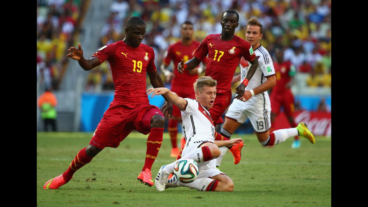 Toni Kroos of Germany is challenged by Jonathan Mensah, left,  and Mohammed Rabiu of Ghana. 