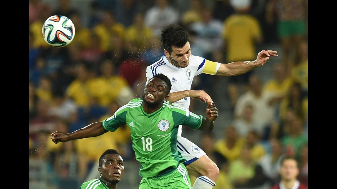 Nigeria forward Michael Babatunde jumps to head the ball with Bosnia-Herzegovina defender and captain Emir Spahic.