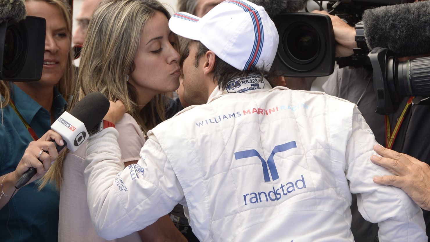Sealed with a kiss: Felipe Massa embraces his wife Raffaaela Bassi after taking pole in Austria.