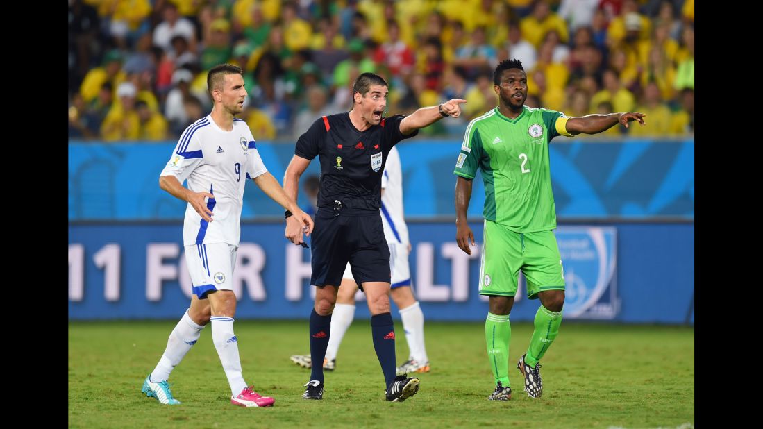 Referee Peter O Leary makes a point to Joseph Yobo of Nigeria and Vedad Ibisevic of Bosnia.