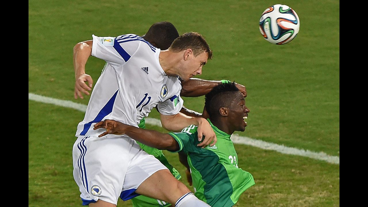 Bosnia- Herzegovina forward Edin Dzeko, left, heads the ball near Nigeria defender Kenneth Omeruo.
