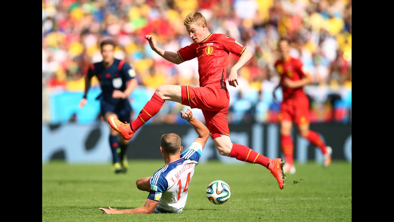 Kevin De Bruyne of Belgium tries to dodge a tackle by Vasily Berezutskiy of Russia.