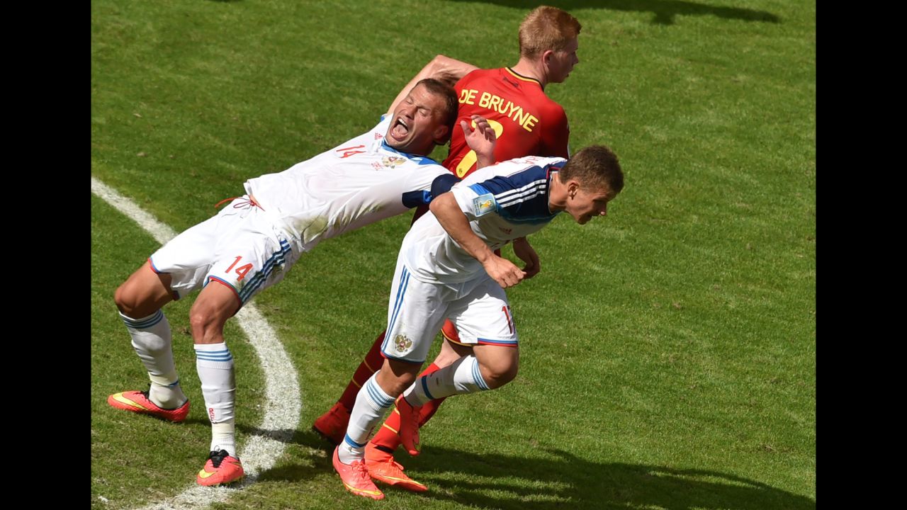 Belgium's midfielder Kevin De Bruyne is challenged by Russia's defender Vasily Berezutskiy, left, and midfielder Oleg Shatov.