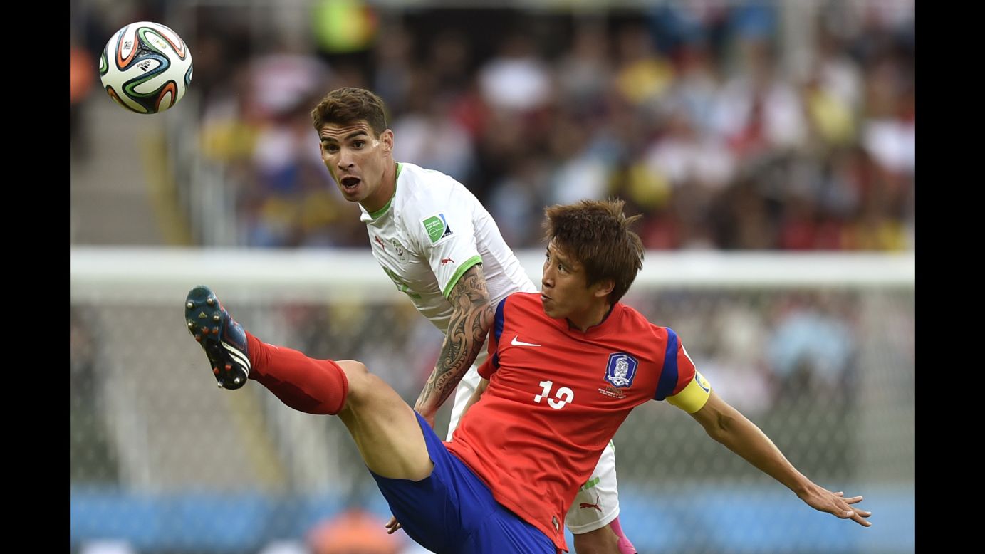 South Korea's Koo Ja-cheol reaches for the ball in front of Algeria's Carl Medjani.