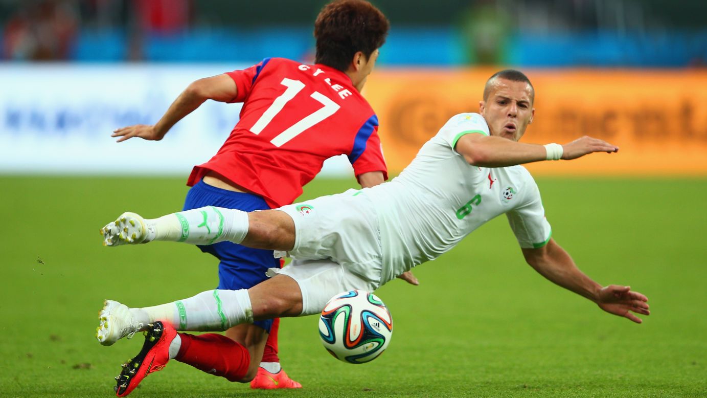 Djamel Mesbah of Algeria vies for the ball with Lee Chung-yong of South Korea.
