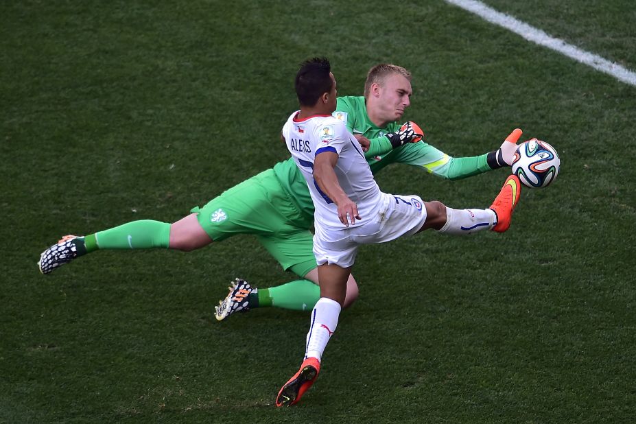 Chile forward Alexis Sanchez, front, competes for the ball with Netherlands goalkeeper Jasper Cillessen.