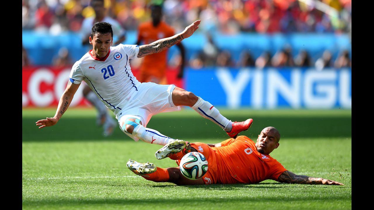 Charles Aranguiz of Chile is tackled by Nigel de Jong of the Netherlands.