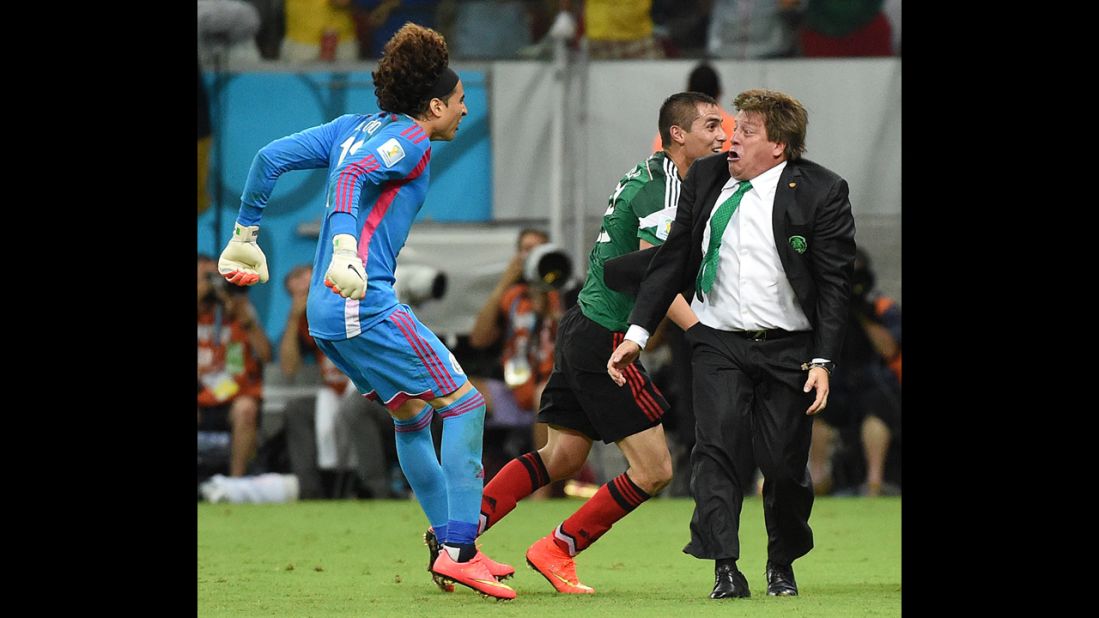 Mexican goalkeeper Guillermo Ochoa, left, and coach Miguel Herrera celebrate a goal by their team during a World Cup match against Croatia on Monday, June 23, in Recife, Brazil. Mexico won 3-1.