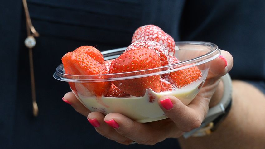 A spectator carries strawberries and cream on day three of the 2013 Wimbledon Championships tennis tournament at the All England Club in Wimbledon, southwest London, on June 26, 2013.