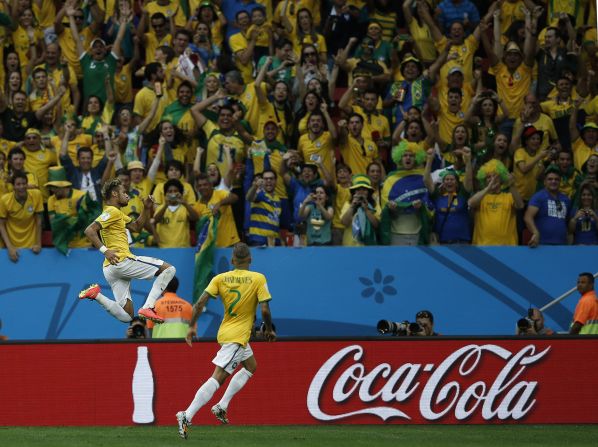 Brazil forward Neymar, left, celebrates with his teammate Dani Alves after scoring Brazil's second goal against Cameroon.