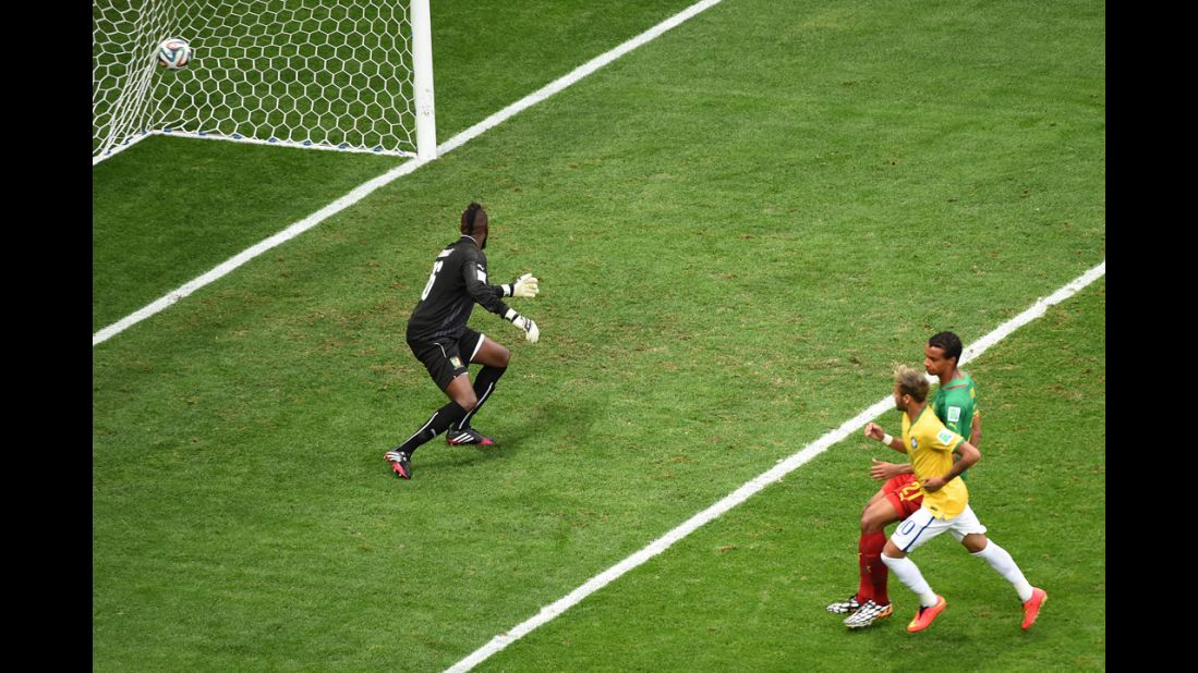 Brazil forward Neymar, right, scores Brazil's first goal past Cameroon goalkeeper Charles Itandje.