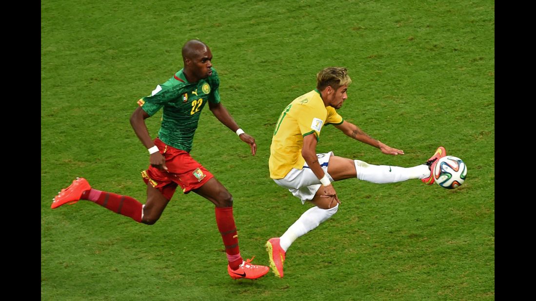 Cameroon defender Allan Nyom, left, and Brazil forward Neymar compete for the ball.