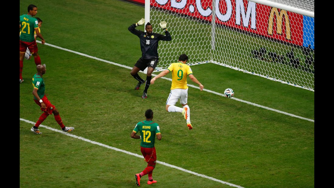 Fred of Brazil scores his team's third goal on a header past Charles Itandje of Cameroon.