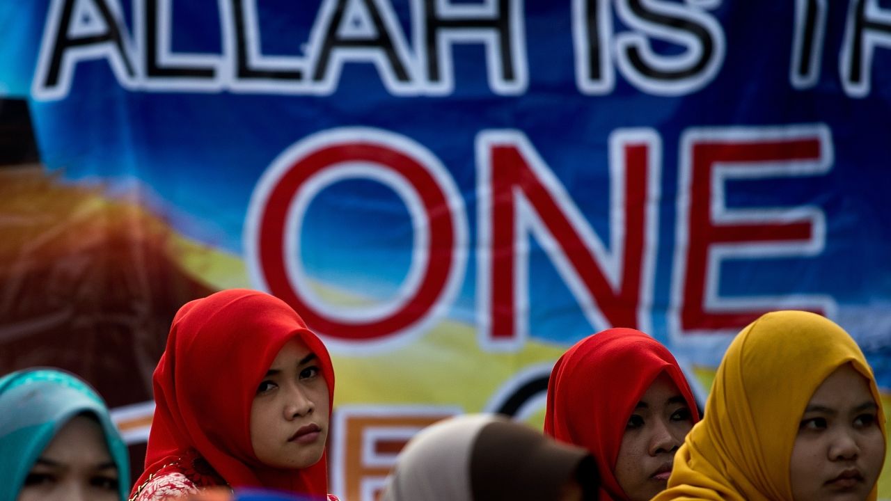 Muslim activists wait outside Malaysia's highest court in Putrajaya for the verdict on June 23, 2014.