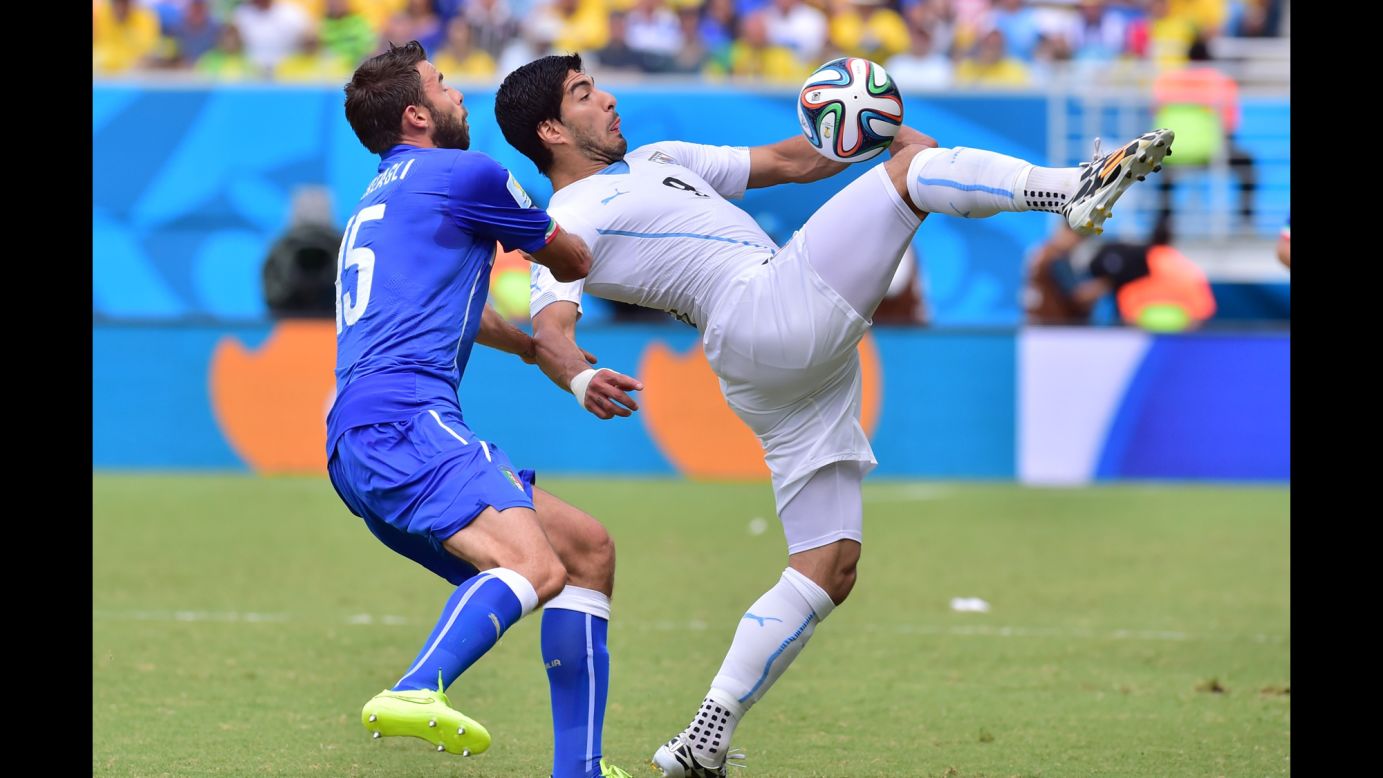 Italy defender Andrea Barzagli, left, and Uruguay forward Luis Suarez vie for the ball. 