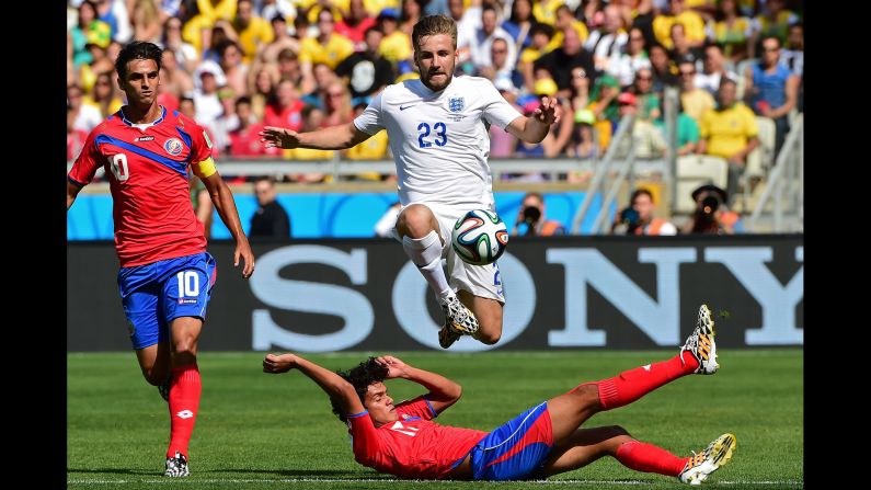 England defender Luke Shaw jumps over a Costa Rica player while going after the ball. 