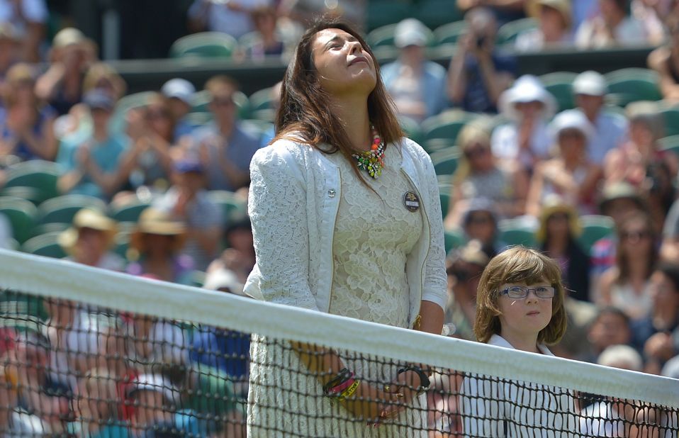 Marion Bartoli, the 2013 Wimbledon women's singles champion, takes part in an emotional ceremonial coin toss on Centre Court in honor of former British No. 1 Elena Baltacha who died from cancer at the beginning of May.