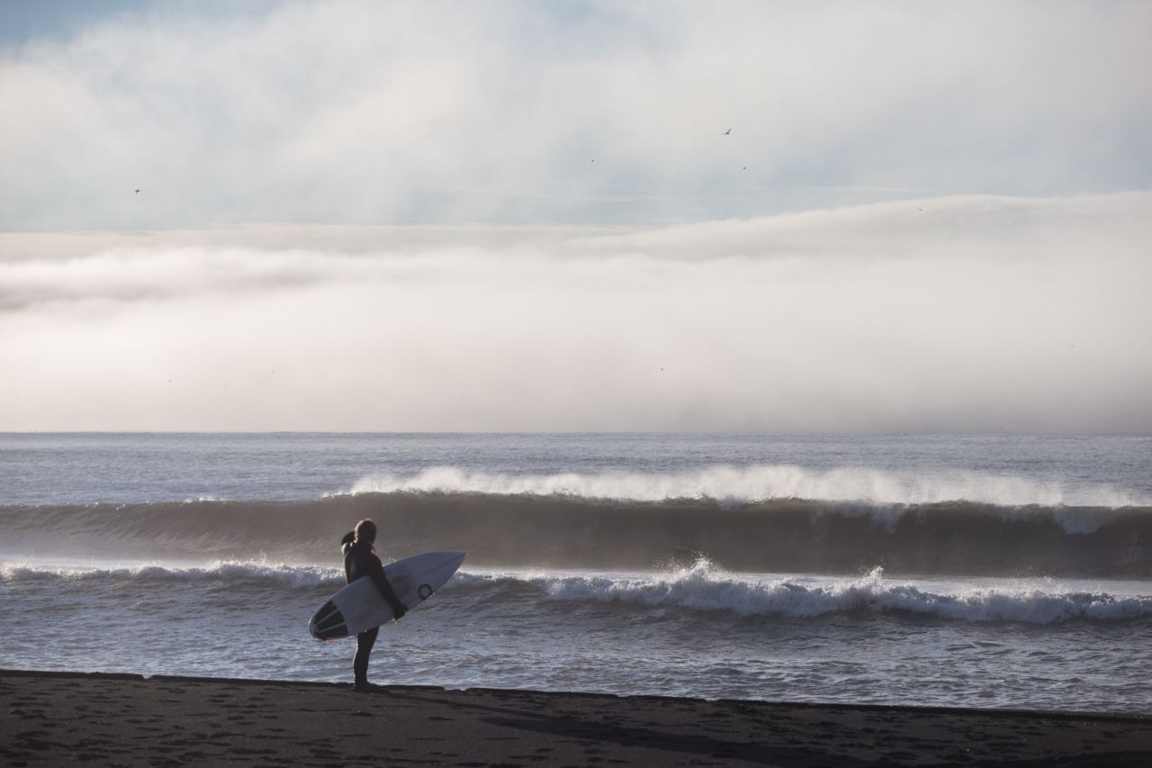 Surfing around Reykjanes, Iceland, presents various challenges, not least the freezing temperatures, making wetsuits and foot protection essential.