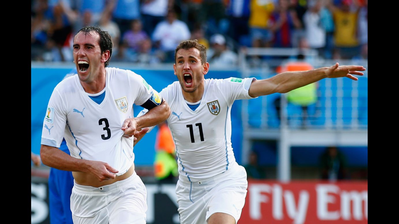 Diego Godin of Uruguay, left, celebrates scoring his team's first goal during a match against Italy in Natal, Brazil. Uruguay won 1-0.